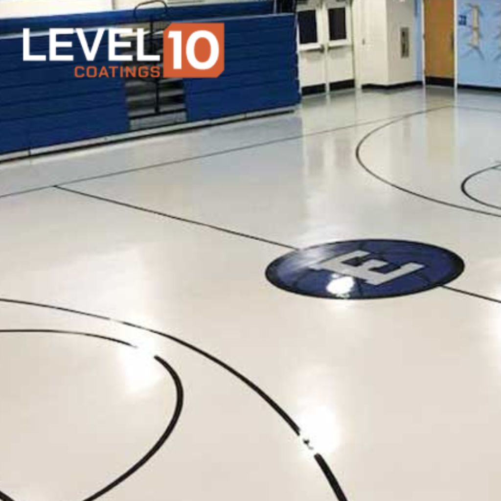 Durable white epoxy flooring in a school gym, designed for high-traffic areas.