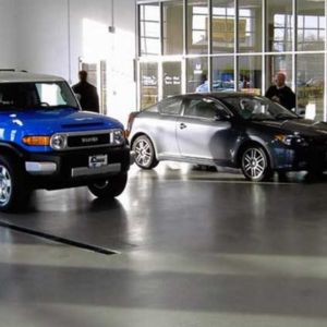 Sleek polished concrete floor in a modern car dealership showroom highlighting vehicle aesthetics.
