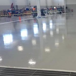 Polished dark gray concrete floor sprawling across a warehouse.