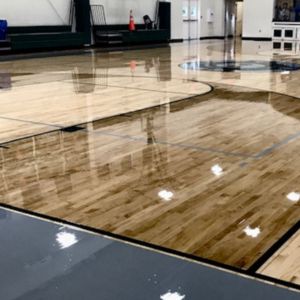 Indoor basketball court with polished concrete painted to mimic wood.