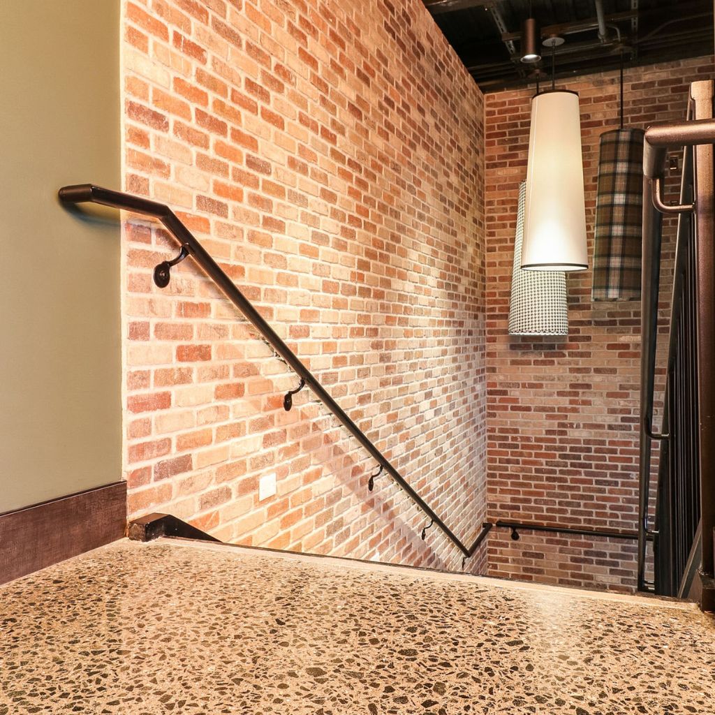 Grind and seal concrete floor leading to a staircase in a stylish restaurant.