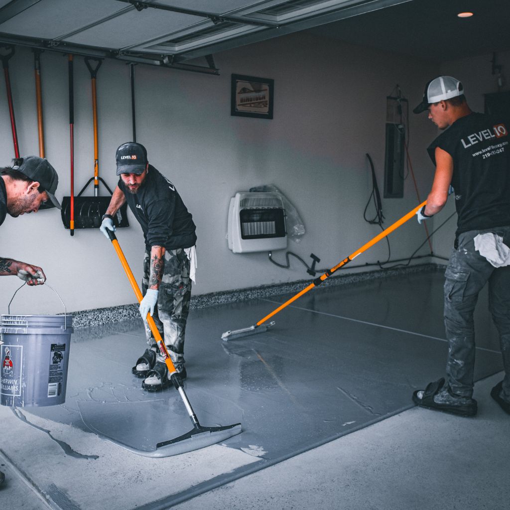 Level 10 Coatings team applying epoxy on a garage floor.