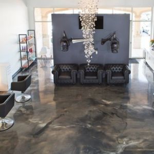Dark gray marbled concrete floor giving depth to a modern salon.